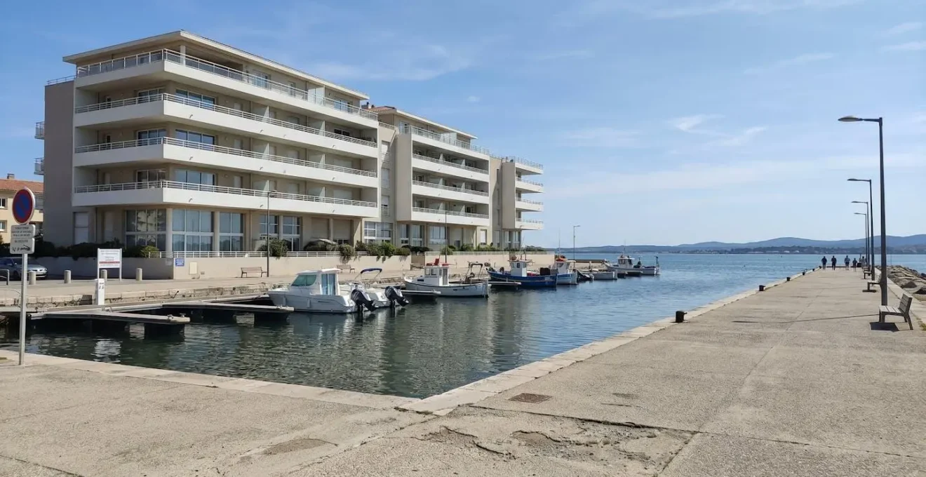 Vue extérieure d'une résidence récente avec balcons donnant sur l'étang de Thau à Balaruc-les-Bains sous un ciel méditerranéen ensoleillé